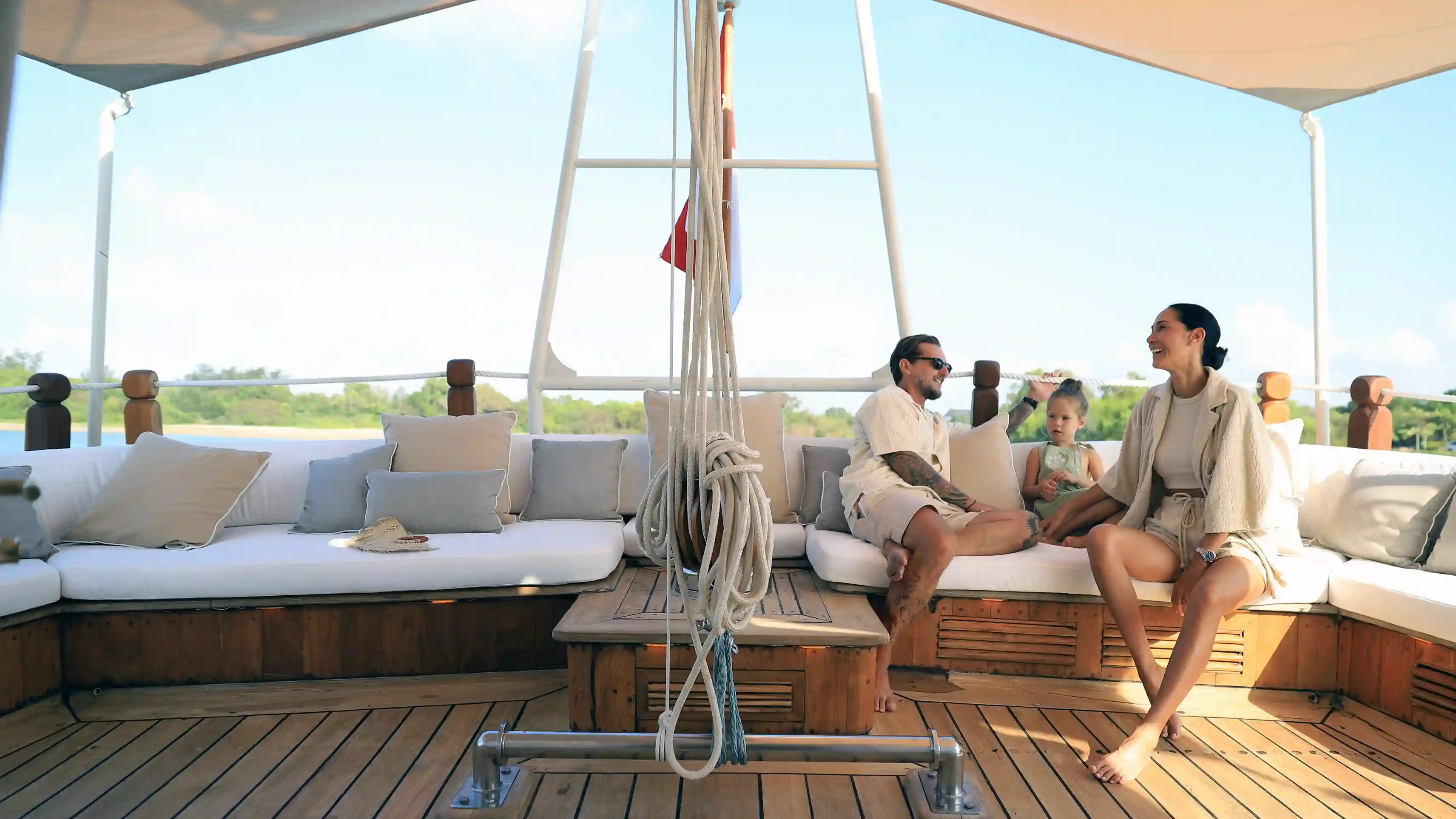 Family with young child relaxing on a phinisi boat deck in Komodo — Komodo National Park