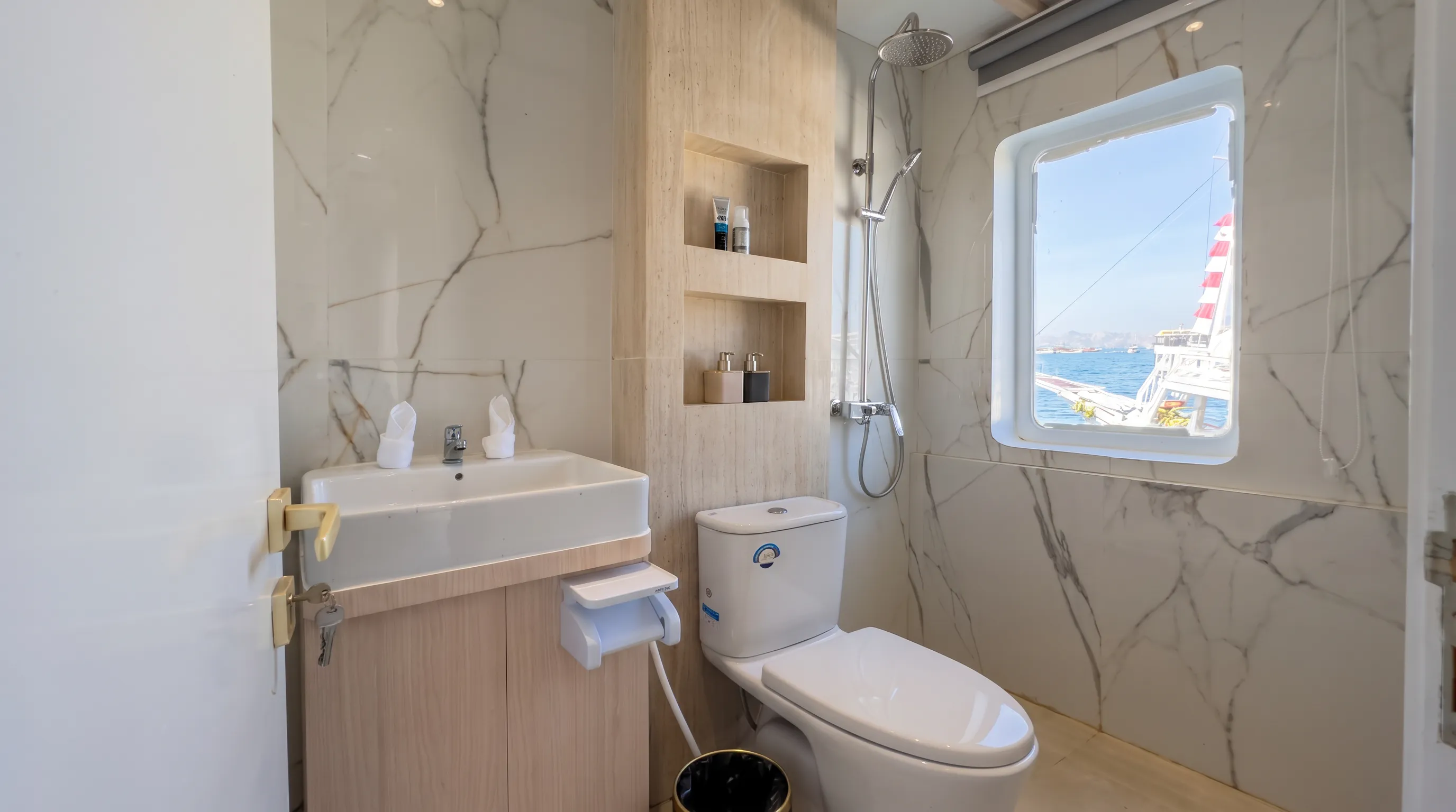 En-suite bathroom with sea-view window aboard Lasha